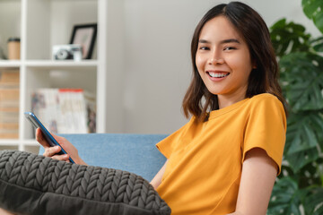 Cheerful young woman holding a smartphone and using online social on lifestyle. Technology for communication concept.