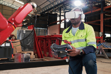 An African American engineer with VR glasses controls robotic arm, virtual simulator software in mechanical manufacturing factory, and intelligent automatic machines technology in industry innovation.