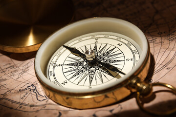Golden compass on world map, closeup
