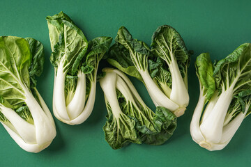 Fresh pak choi cabbages on green background, closeup - obrazy, fototapety, plakaty