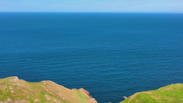 St. Abbs Head coastal cliffs and village of St. Abbs aerial view in summer, Berwickshire, Scotland, UK. 