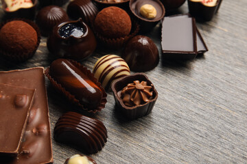 Chocolate bars and candies on wooden background, closeup