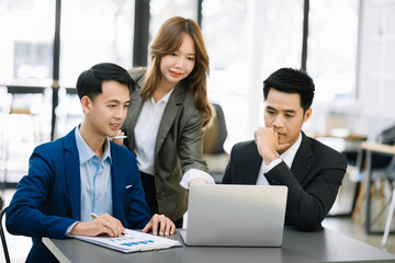 Office colleagues have a casual discussion. During a meeting in a conference room, a group of business teem sit in the conference room startup project.