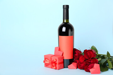 Roses with bottle of wine, gift and hearts on blue background. Valentine's Day celebration