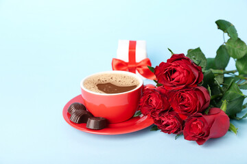 Roses with cup of coffee, candies and gift on blue background. Valentine's Day celebration