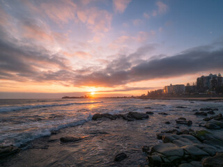 Obraz premium Coastal Sunrise with Waves Crashing