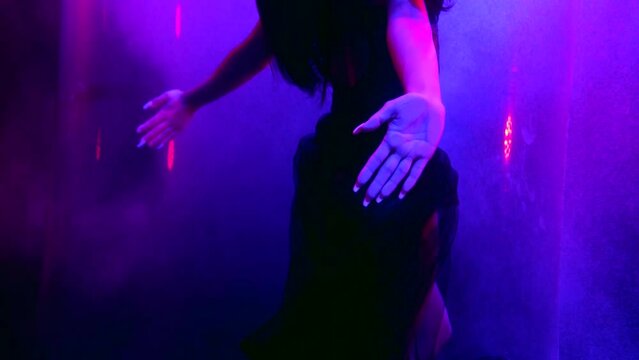 artistic underwater shot with beautiful female figure, body and hands, floating in purple water