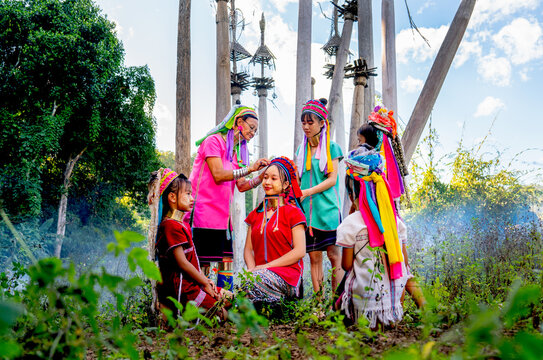 Various generation include young teen and old woman help to decorate and set hair and cloth of lovely Long Neck Karen and they stay in area of ceremonial courtyard of their village.