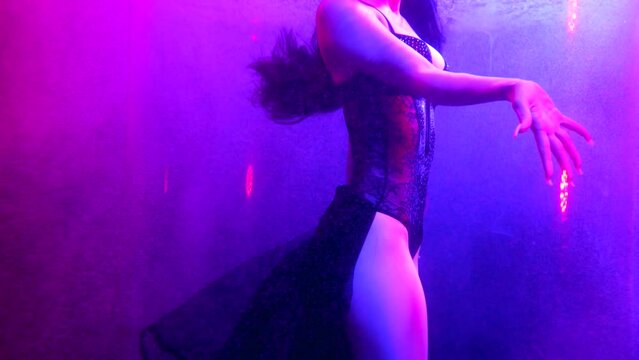 misteriuos seductive woman inside depth of pool with dramatic purple light, underwater view on body