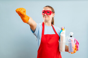 Woman in red mask, gloves and apron holding basket with cleaning supplies