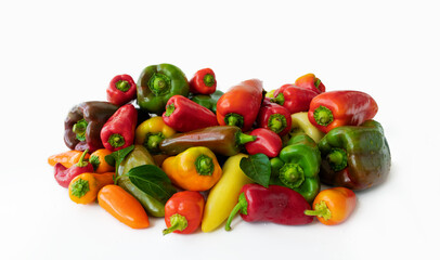 Red, green and yellow fresh bell peppers on a white background. Vegetable background from sweet pepper, paprika. Washed harvest from the garden on a white table.