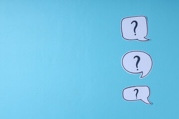 Question marks on blue background with copy space. FAQ and education concept.  