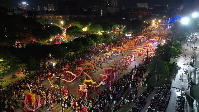 Top view of dragon dance perform celebration new year. Group of people perform a traditional lion dance and dragon dance. Guinness record performance of 54 Dragons dance on the street Vung Tau.