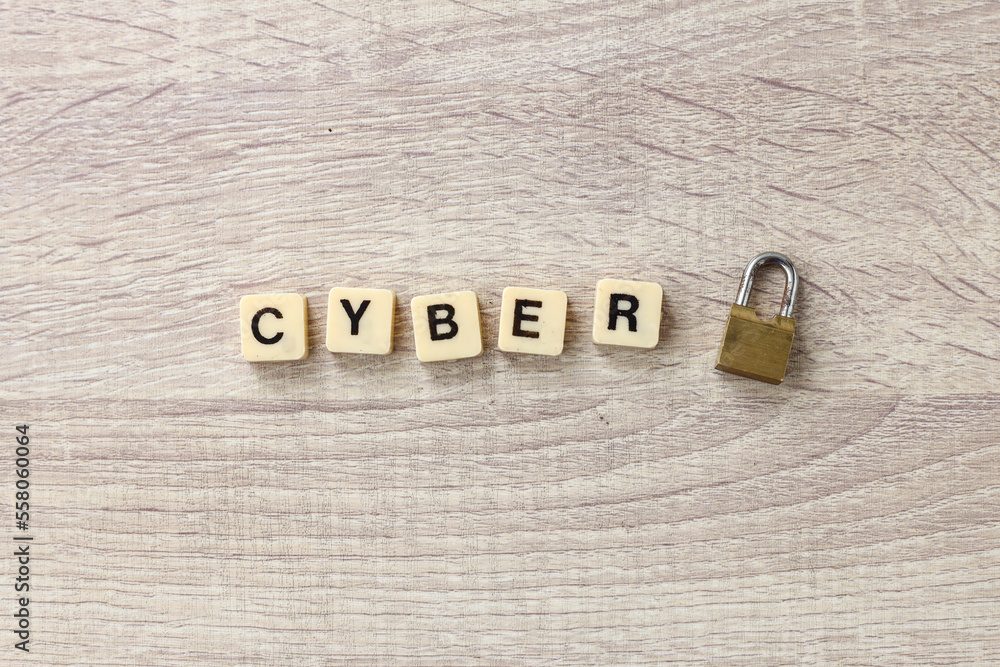 Poster the word cyber formed by alphabet square tiles with lock on wooden background. cyber security concep