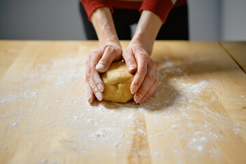 Woman kneads dough with her hands