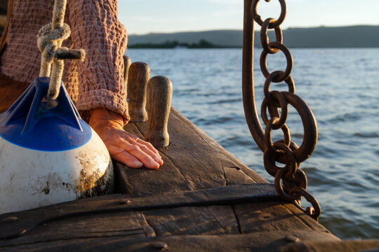 Close up of wrinkled sailor hand, sailing into the sunset. Experienced marine sailing at sea