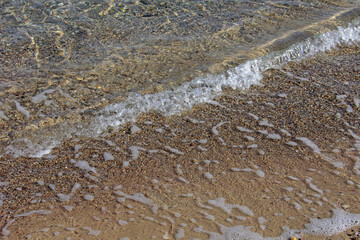 Fototapeta na wymiar petite vague sur le sable