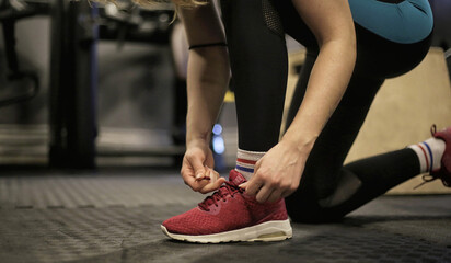 Woman Tying Her Shoes at the Gym
