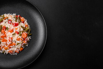 Delicious fresh risotto with vegetables, spices and herbs on a black plate