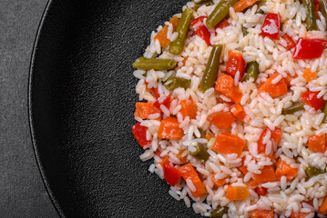Delicious fresh risotto with vegetables, spices and herbs on a black plate