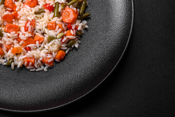 Delicious fresh risotto with vegetables, spices and herbs on a black plate