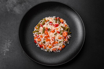 Delicious fresh risotto with vegetables, spices and herbs on a black plate