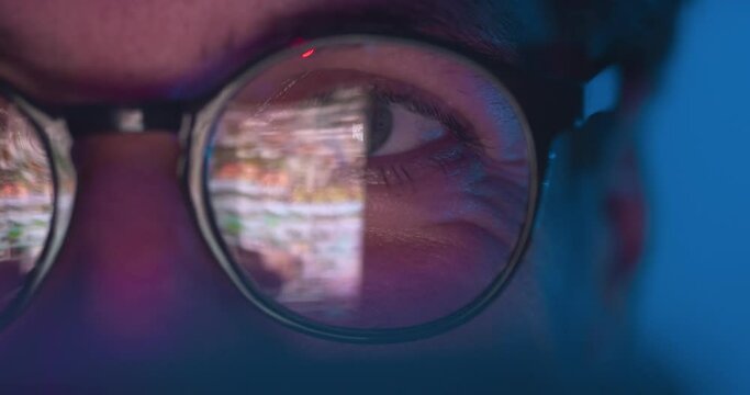 Reflection in glasses, closeup face millennial man scrolling pages online of smartphone, social networks. Close up portrait man in glasses using smartphone browsing internet at night, double exposure.