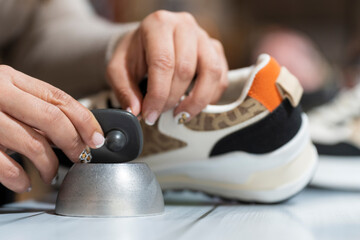 Clothing store clerk removing the alarm from a piece of clothing