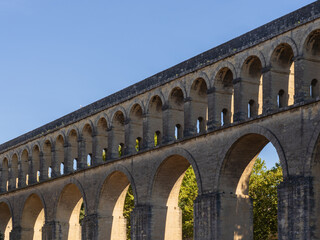 Fototapeta na wymiar Scenic summer landscape view of ancient St Clement aka Arceaux aqueduct stone building, famous historic landmark of Montpellier, France 