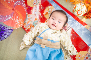 お正月に日本的で和風の袴姿で寝転ぶ生後3か月の赤ちゃん