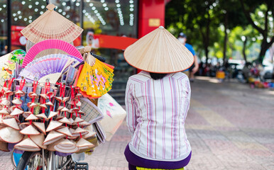 In Ho chi minh city, Vietnam, an unidentified woman rides a bicycle with baskets. Bicycle-based...