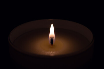 Candle flame in glass laid on dark place in the night
