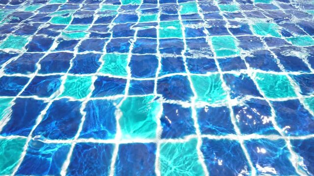 Water surface with waves on water surface wave effect You can see the blue square tiles at the bottom of the pool.