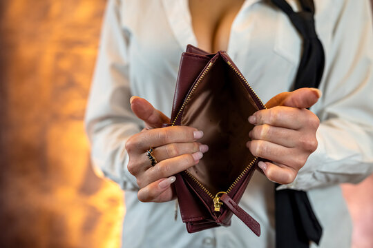 Close-up image of girl's hands with an open empty purse in her hands.