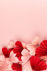 Bright and passion Valentines day background - heap of mix of pink and red paper ribbed hearts on soft light pastel pink background as footer border with copy space, top view, vertical.