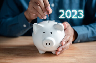 2023 saving planning concept. man putting piggy bank for deposit banking of investment , retirement planning future saving, invest for profit and interest.