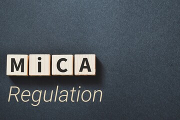 Markets in Crypto-Assets (MiCA) Regulation inscription on wooden blocks on dark background.