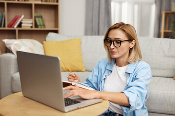 Smiling Woman Working Laptop. Nice Beautiful Lady With Blonde Hair Work At Notebook At Home. Technology Woman Concept 