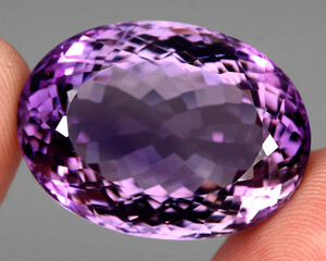 Natural gemstone purple amethyst on gray background