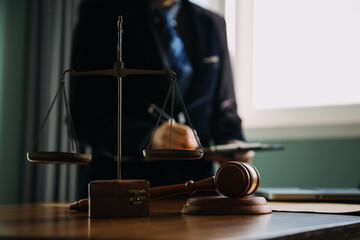 Business and lawyers discussing contract papers with brass scale on desk in office. Law, legal services, advice, justice and law concept picture with film grain effect