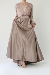 Studio shot of female fashion model in beige maxi circle skirt, Simplistic and elegant silk satin full length skirt