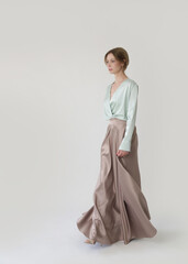 Studio shot of female fashion model in beige maxi circle skirt, Simplistic and elegant silk satin full length skirt