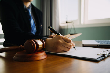 Business and lawyers discussing contract papers with brass scale on desk in office. Law, legal services, advice, justice and law concept picture with film grain effect