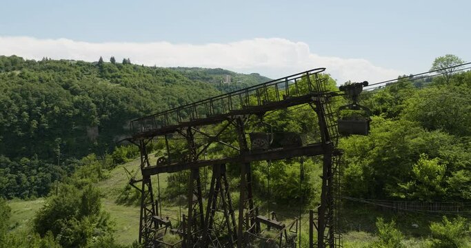 Old rusty freight cableway pylon on wooded hillside, Chiatura, Georgia.