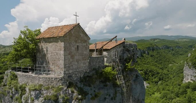 Katskhi monastery on tall rock pillar plateau above georgian landscape.