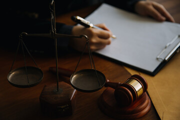 Business and lawyers discussing contract papers with brass scale on desk in office. Law, legal services, advice, justice and law concept picture with film grain effect