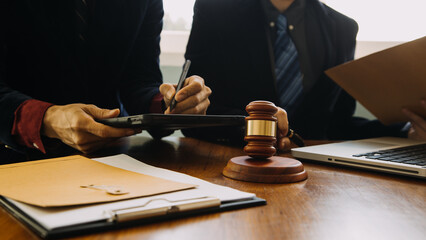 Business and lawyers discussing contract papers with brass scale on desk in office. Law, legal services, advice, justice and law concept picture with film grain effect