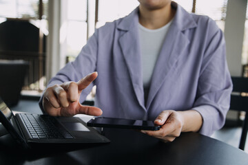 Asian colleagues man and woman discussing and working with laptop computer on office desk in the office