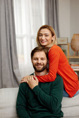 Fototapeta premium Romantic Couple Embracing Sofa. Happy Couple Relaxing On Couch At Home. Smiling Loving Spouses Resting In Cozy Living Room Interior, Embracing On Sofa, Enjoying Weekend Time Together 