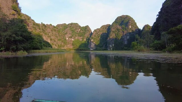 Ninh Binh, Vietnam: Point of view of the row boat on the Tam Coc river, a famous natural landmark near Ninh Binh in northern Vietnam with stunning karst formation reflection